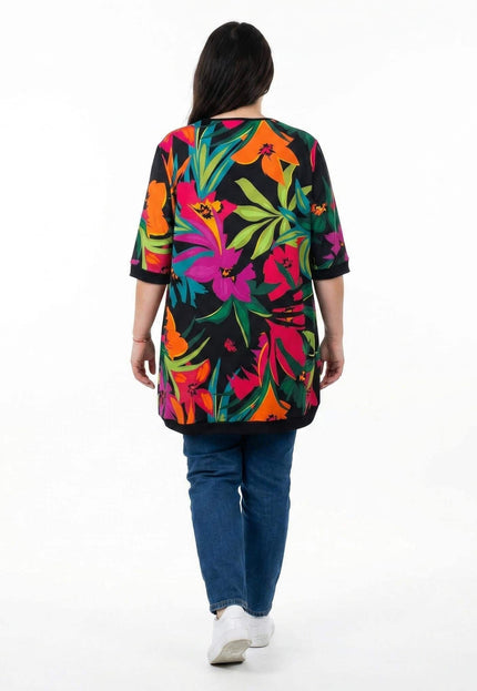 Шарена лятна туника големи размери с едър тропически флорален принт. Изглед отзад на модела, заснет в цял ръст на бял фон.