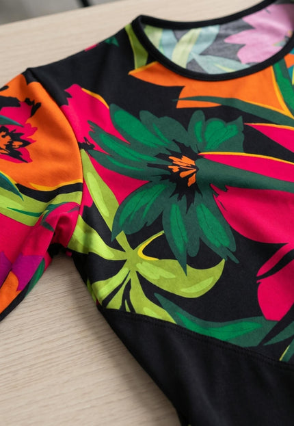 Детайл отблизо на шарена лятна туника големи размери, показващ едър тропически флорален принт, обло деколте и ръкав.