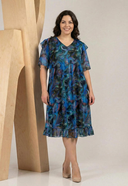 Шарена официална рокля големи размери с ефектен ръкав и шифон, V-образно деколте и абстрактен принт в синьо, заснета в цял ръст.
