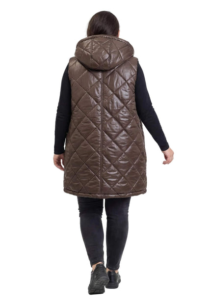 Шоколадово кафяв дълъг ватиран елек с качулка, сниман отзад, показващ ефектното капитониране на ромбове и дължината на модела.