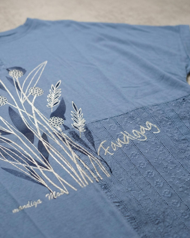 Детайл отблизо на синя лятна туника големи размери с флорална апликация, бродерия и красива дантела, разположена плосък кадър.