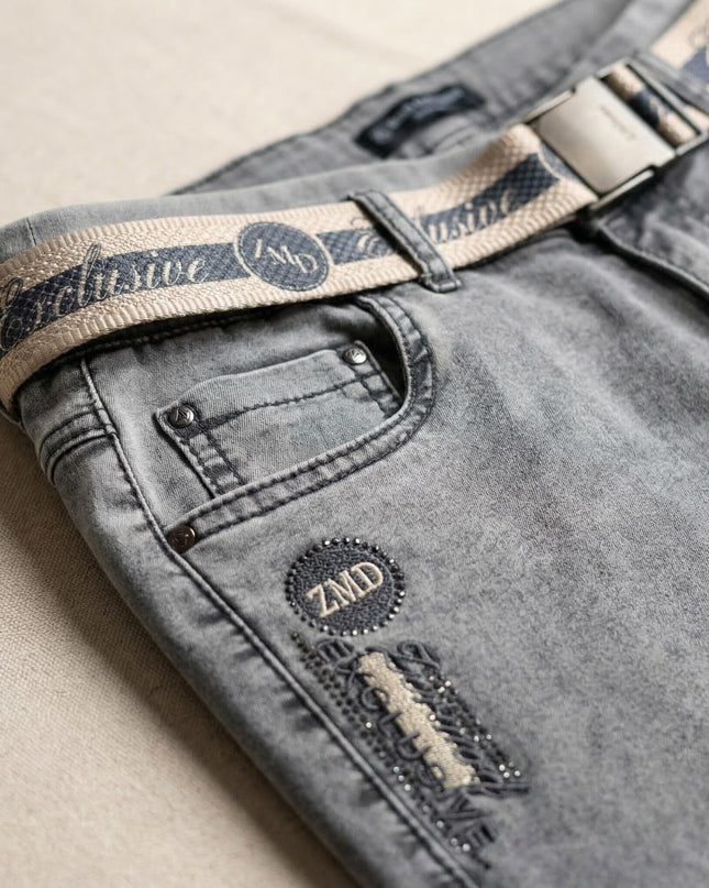 Детайл отблизо на сиви ежедневни макси дънки с ластик, преден джоб, текстилен колан с катарама и емблема с лого ZMD.