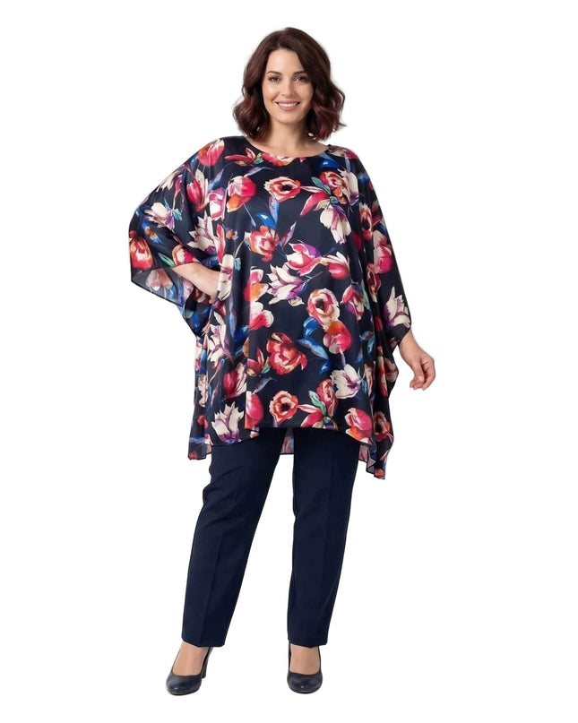 Тъмносиня официална макси туника на цветя тип пончо. Моделът е показан в цял ръст, демонстрирайки ефирния шифон с флорален принт и асиметричния подгъв.