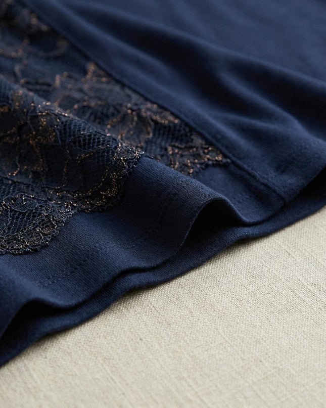 Детайл отблизо на тъмносиня официална макси туника, показващ ефектната флорална дантела със златисти нишки и гладко трико.