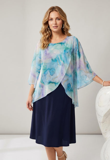 Тъмносиня официална рокля големи размери с ефирно шифонено наметало с абстрактен акварелен принт, представена отпред на светъл фон.