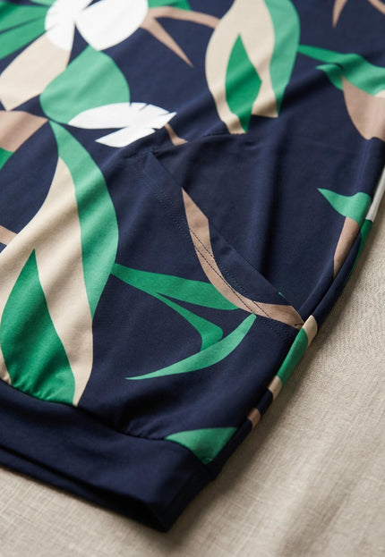 Детайл отблизо на тъмносиня лятна туника големи размери, показващ красивия принт на листа в зелено и бежово, както и практичния преден джоб.