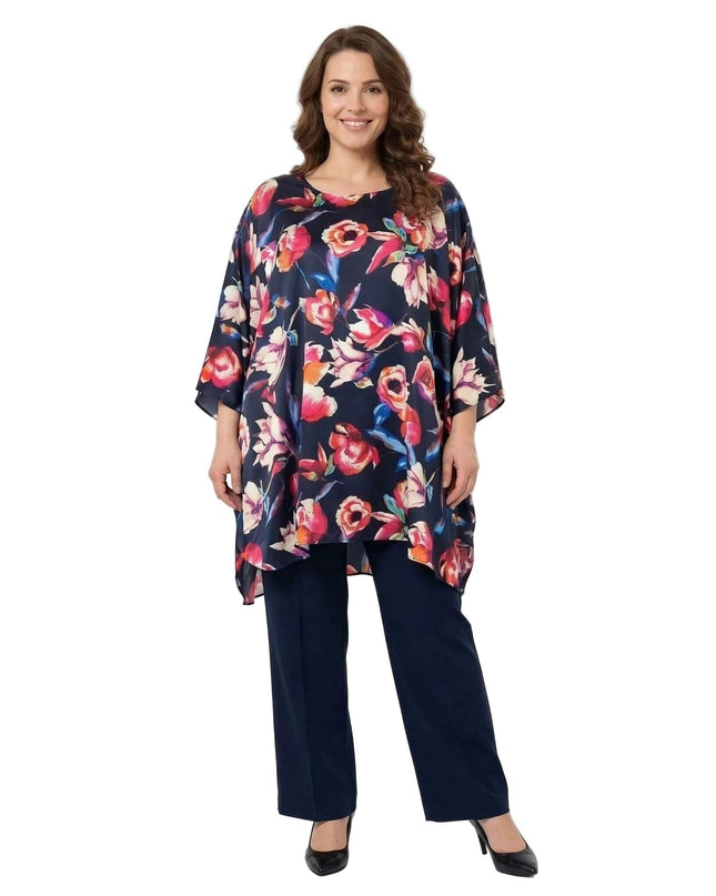 Тъмносиня официална макси туника на цветя тип пончо с ефирен силует и асиметричен подгъв. Представена в цял ръст на бял фон.