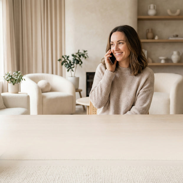 Жена говори по телефон и се усмихва в уютна обстановка показваща обслужване на клиенти